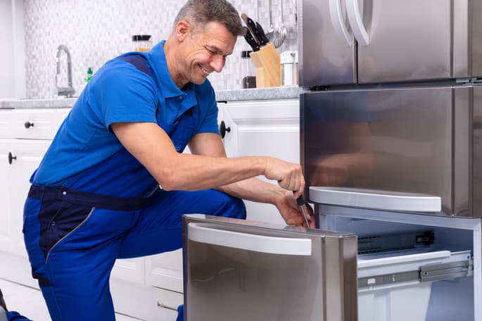 technician repairing a refrigerator